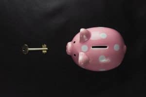 en rosa spargris bredvid en husnyckel i en artikel om hur attefallshus är en god investering